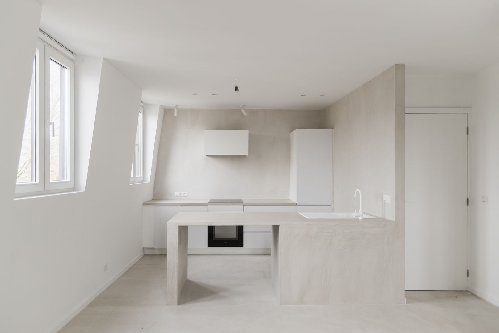 Witte keuken met eiland onder het schuine dak, wanden in microtopping