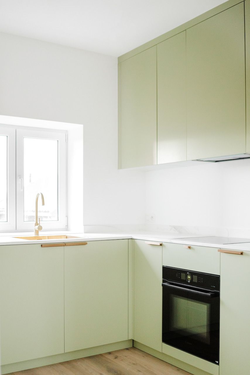 Saliegroene L-keuken met hoge kast en oven