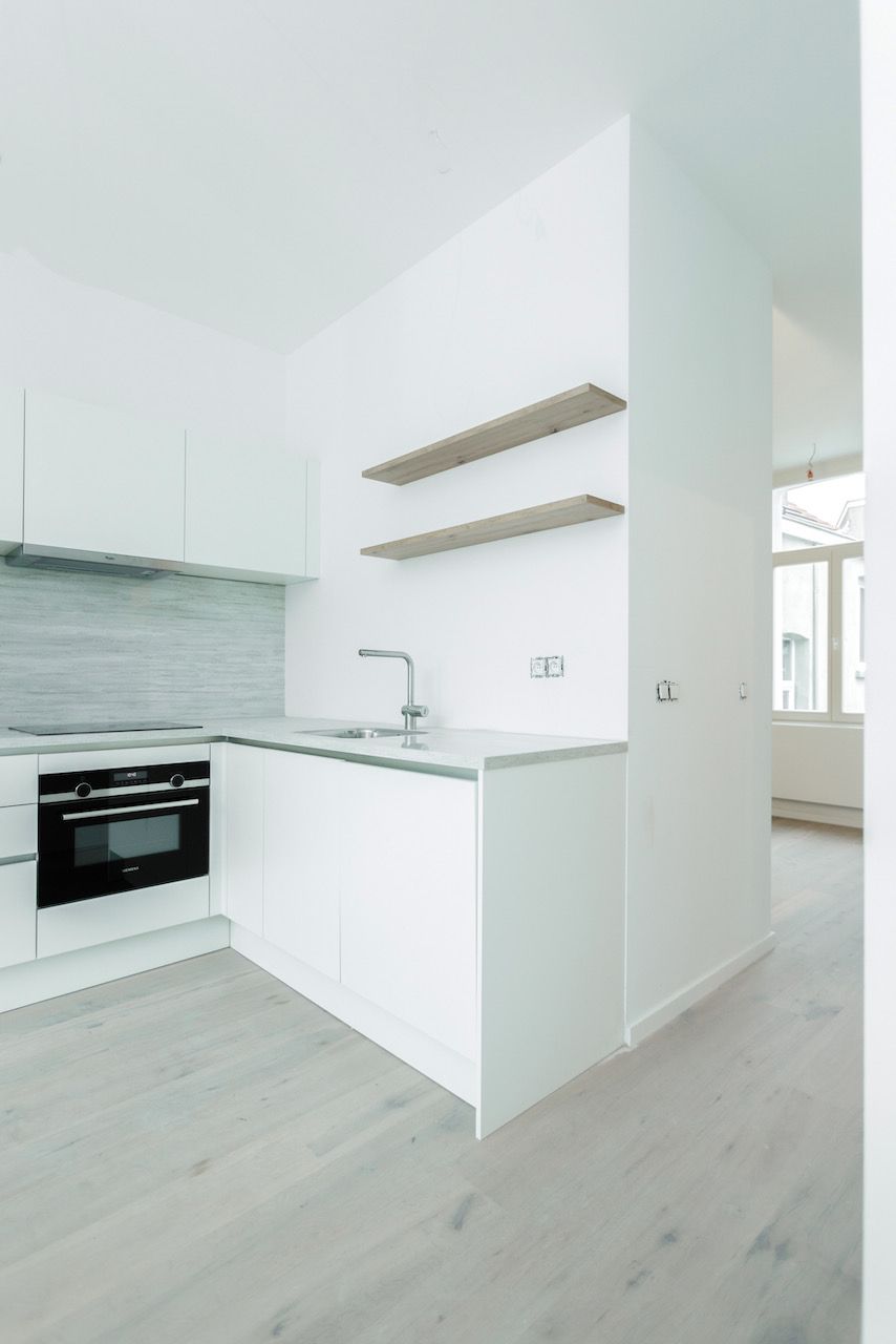 Witte L-keuken met twee eiken legplanken